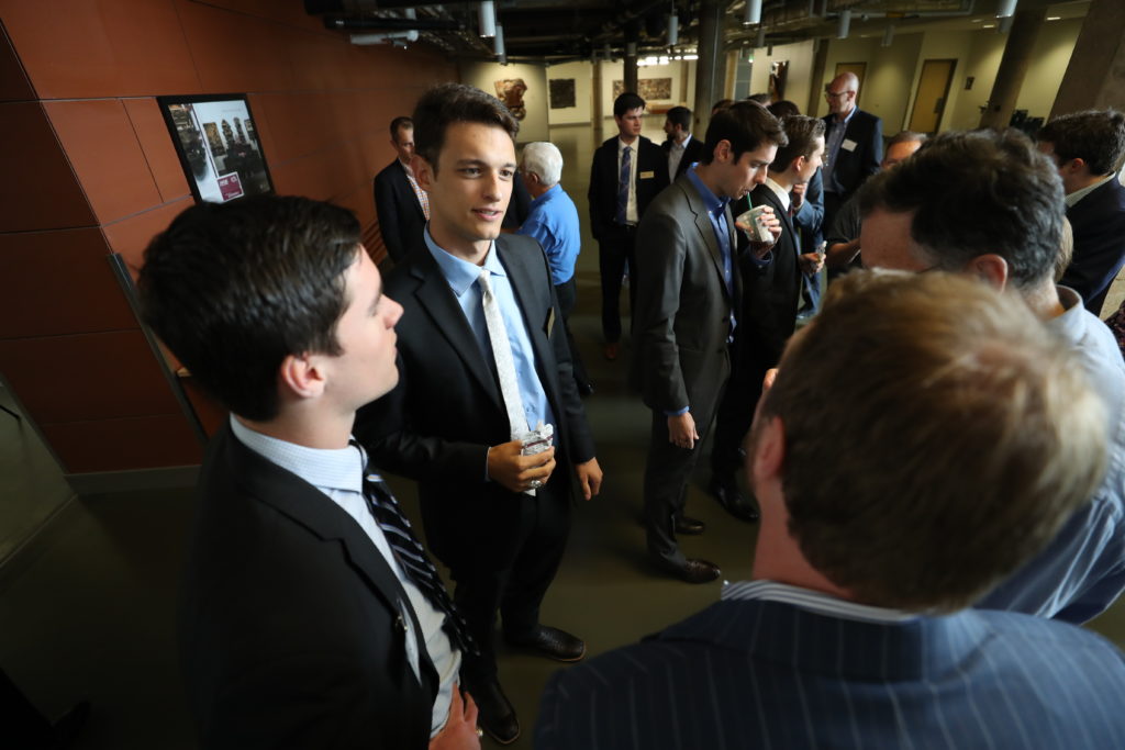 Photo of students and investors in suits and ties mingling at a function